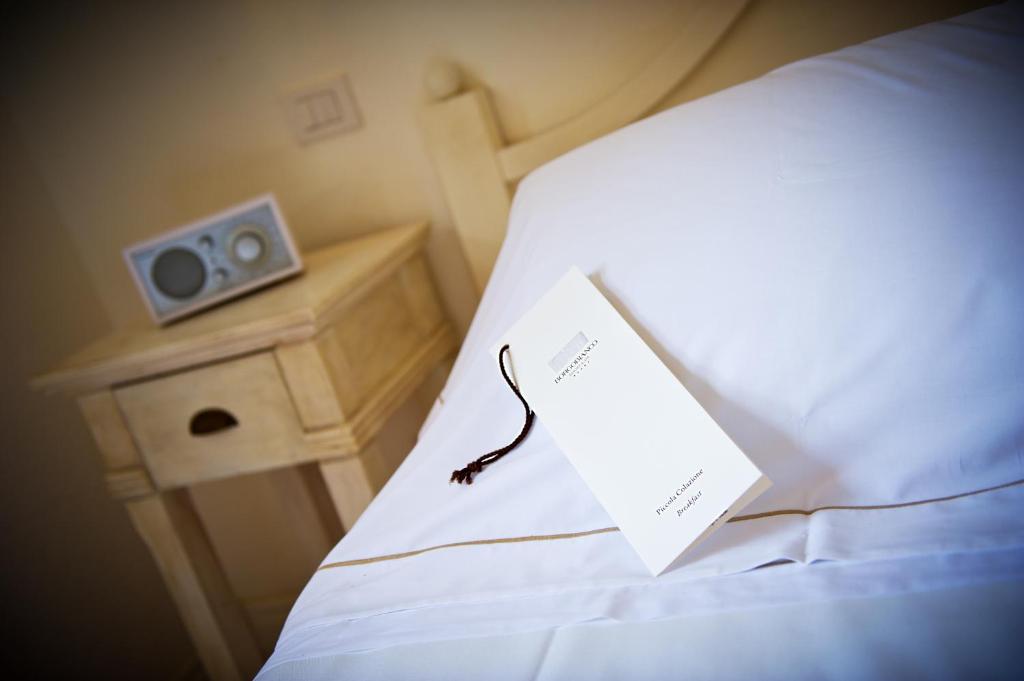 a piece of paper sitting on top of a bed at Borgobianco Resort & Spa Polignano - MGallery Collection in Polignano a Mare