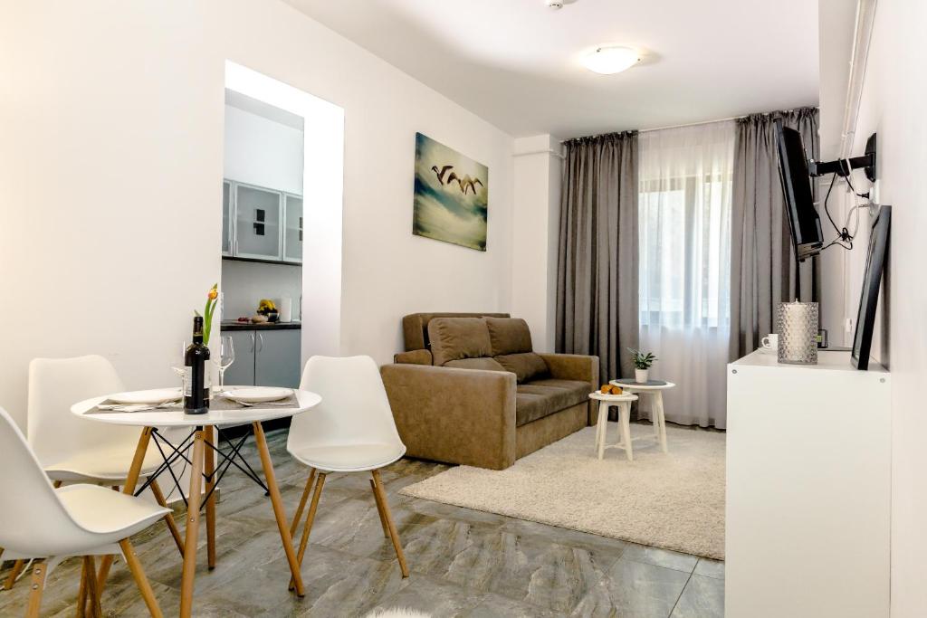 sala de estar con sofá, mesa y sillas en ConceptHT Regim Hotelier en Iaşi