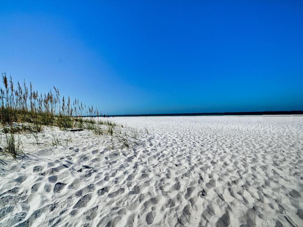 une plage de sable blanc avec des empreintes digitales dans l'établissement Palm Place 2 - Coconut Palm Beach getaway 623, à Clearwater Beach
