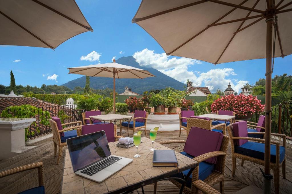 a table with a laptop computer on a patio at Pensativo House Hotel in Antigua Guatemala
