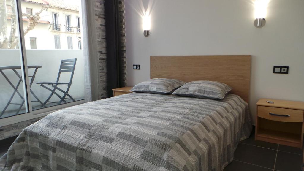 a bedroom with a bed and a large window at Catalans in Marseille