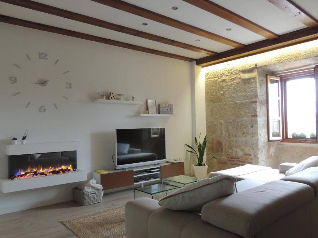 een woonkamer met een bank en een open haard bij Apartamento Ribera Del Puente in Salamanca