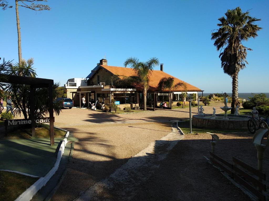a building with a palm tree next to a street at El Descubrimiento Resort Club in Guazuvira
