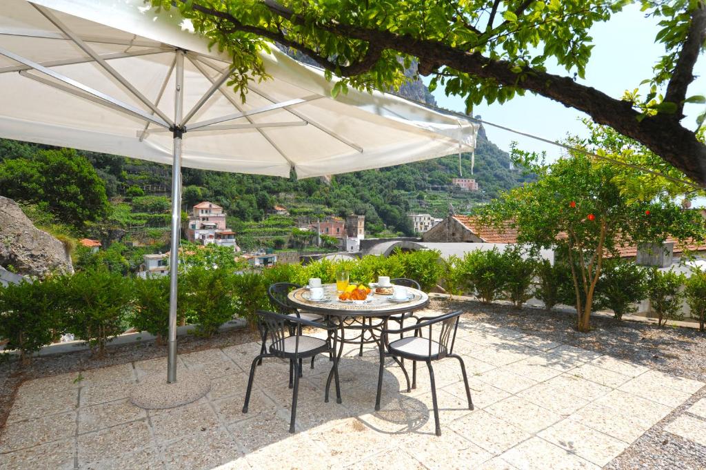 a table and chairs under an umbrella on a patio at Relais San Basilio Convento in Amalfi