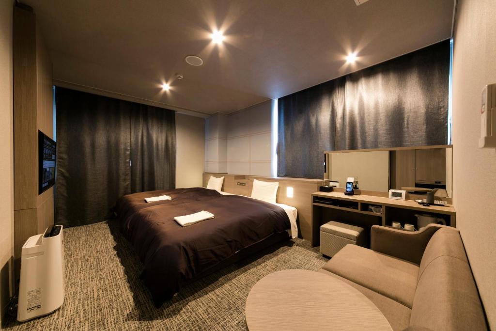 una camera d'albergo con letto e divano di Sanco Inn Nagoya Shinkansen-guchi Annex a Nagoya