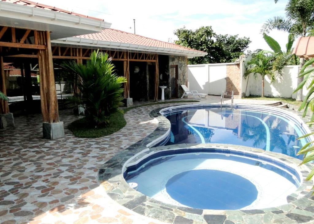 a swimming pool in a yard next to a house at La Casa de la Abuela in Sucúa