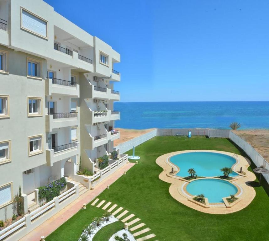 uma imagem de um edifício de apartamentos com piscina em Apartment Essayadi Residence em Port El Kantaoui