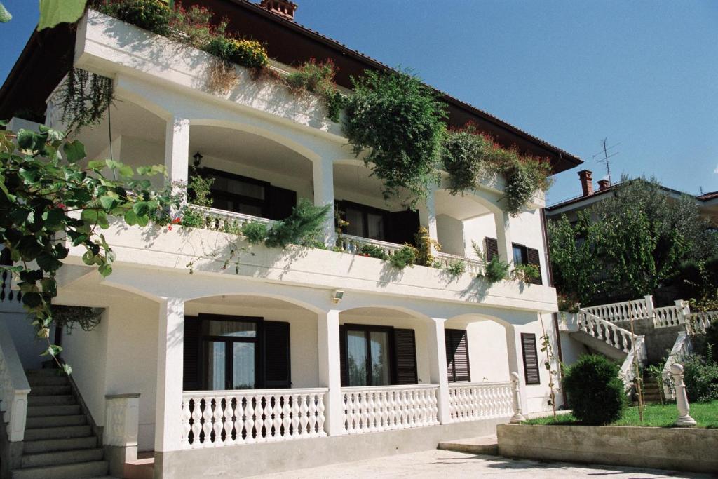una casa blanca con plantas en el balcón en Apartments Ananina, en Portorož