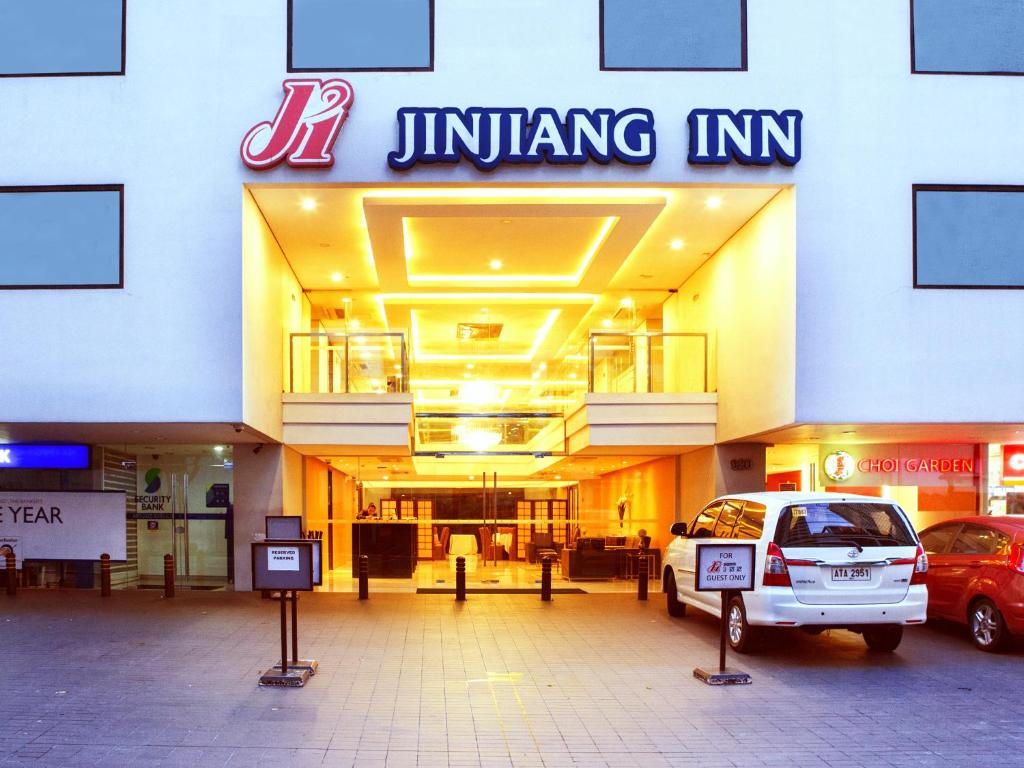 マニラにあるJinjiang Inn - Makatiの車が停まった建物