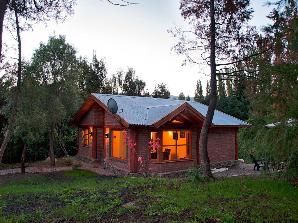 una pequeña casa en medio de un bosque en Camino de los Pioneros en El Bolsón