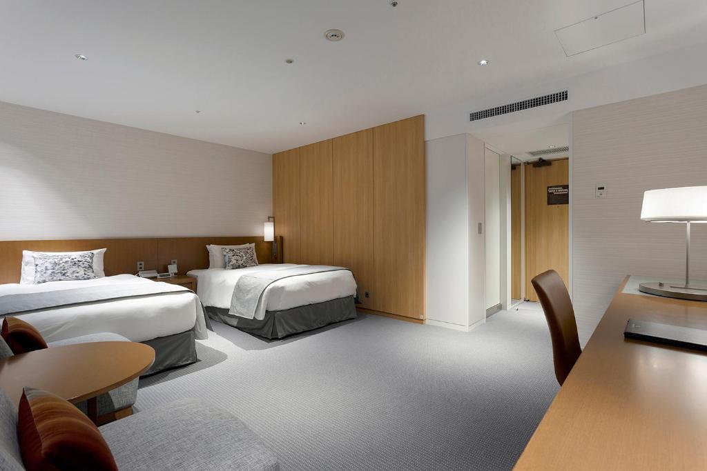 a hotel room with two beds and a table at Keio Plaza Hotel Tokyo in Tokyo