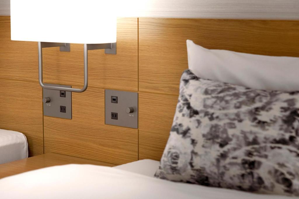 a bedroom with a bed with a pillow and a lamp at Keio Plaza Hotel Tokyo in Tokyo