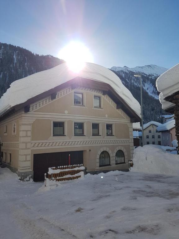 ein schneebedecktes Gebäude, auf dem die Sonne scheint in der Unterkunft Haus am Brunnen in Samnaun