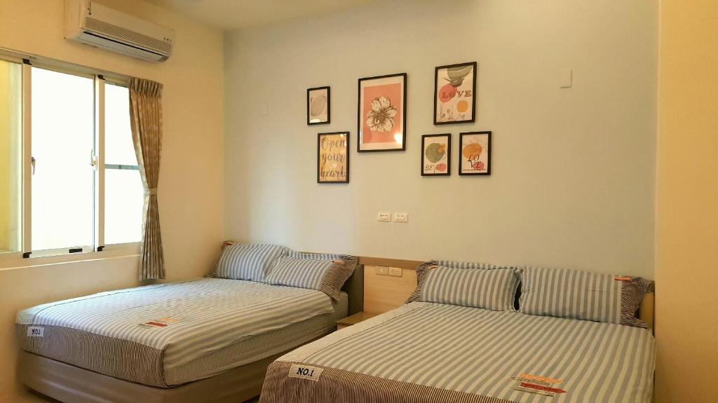 a room with two beds and pictures on the wall at Green Island Dolphin House in Green Island