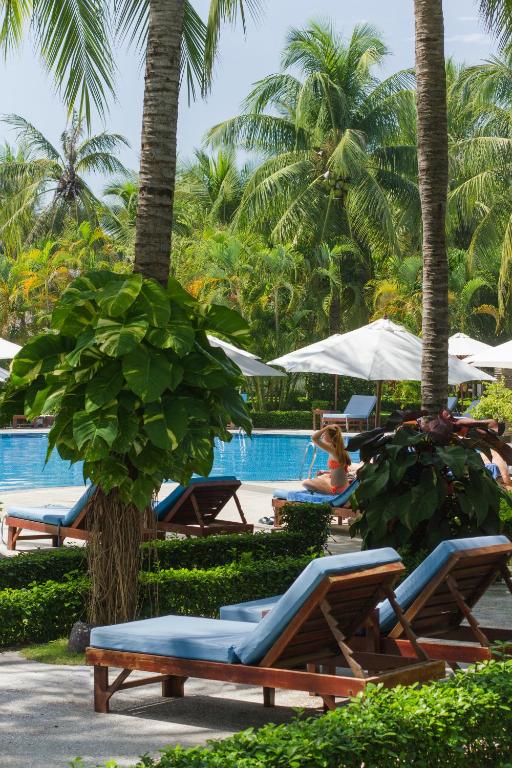 a woman sitting by the pool at a resort at Blue Ocean Resort in Mui Ne