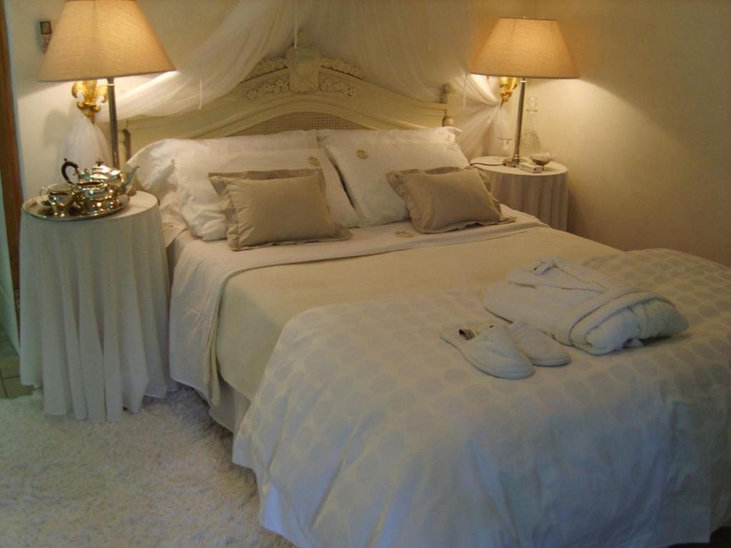 a bedroom with a white bed with two towels on it at Emerald Guest House Springs in Springs