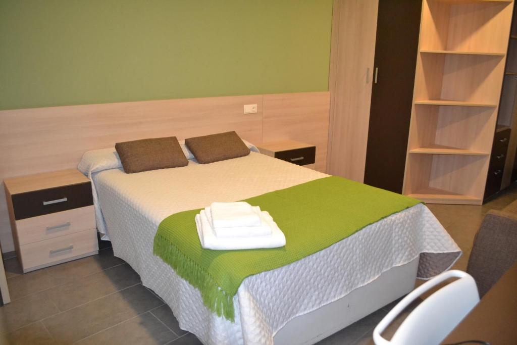 1 dormitorio con 1 cama con 2 toallas en The Factory Residence Hall, en Segovia