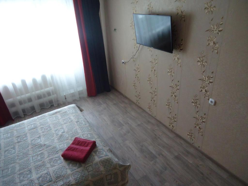 Cette chambre dispose d'une porte avec un tapis et d'une télévision. dans l'établissement Apartments on Gagarina 9, à Volgodonsk