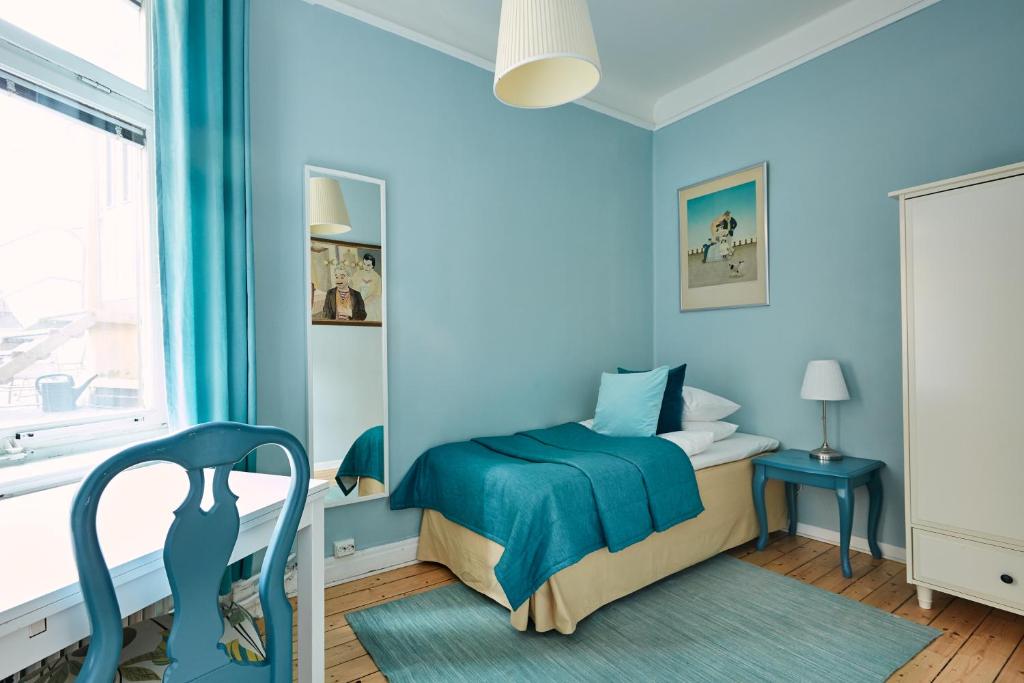 a blue bedroom with a bed and a chair at Hotel Hornsgatan in Stockholm