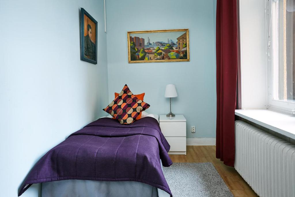 a bedroom with a purple blanket on a bed at Hotel Hornsgatan in Stockholm