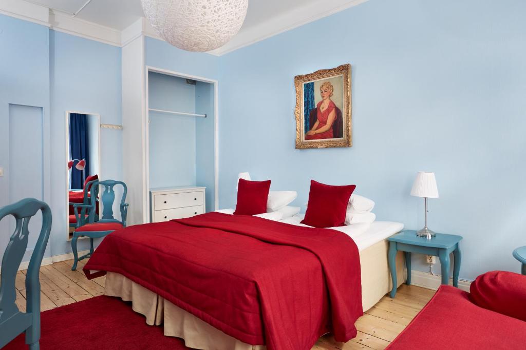 a bedroom with a bed with a red blanket at Hotel Hornsgatan in Stockholm