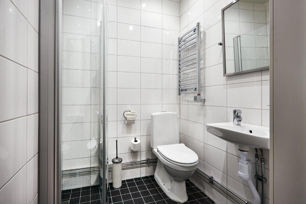 a white bathroom with a toilet and a sink at Hotel Hornsgatan in Stockholm