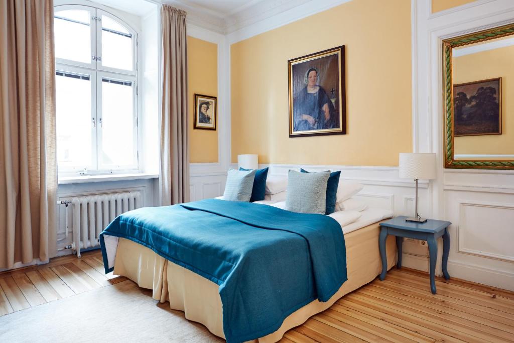 a bedroom with a bed with a blue blanket at Hotel Hornsgatan in Stockholm