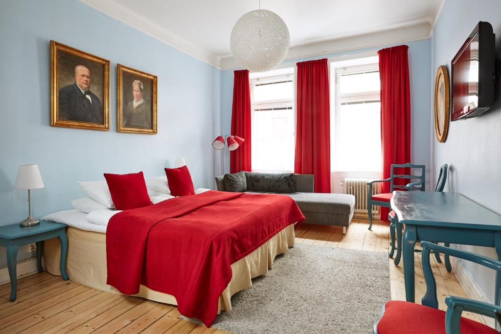 a bedroom with a bed with a red blanket at Hotel Hornsgatan in Stockholm