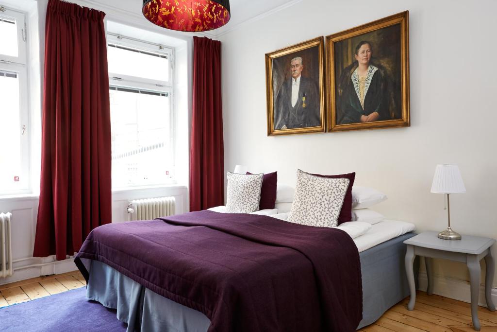 a bedroom with a bed and two portraits on the wall at Hotel Hornsgatan in Stockholm