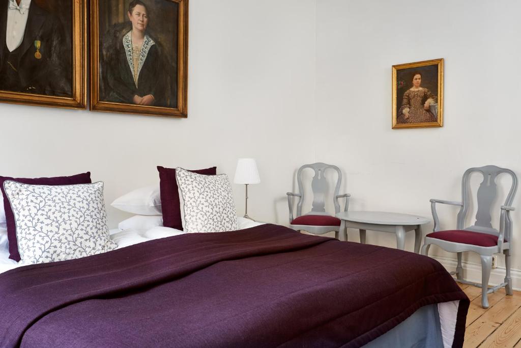 a bedroom with a purple bed and two chairs at Hotel Hornsgatan in Stockholm