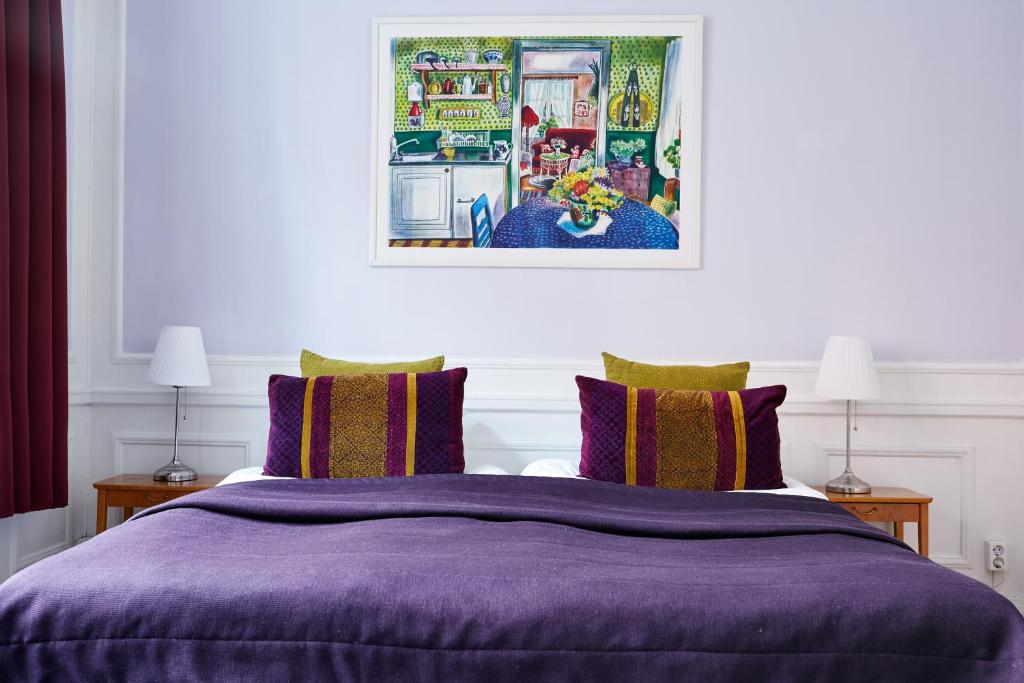 a bedroom with a purple bed with two lamps at Hotel Hornsgatan in Stockholm