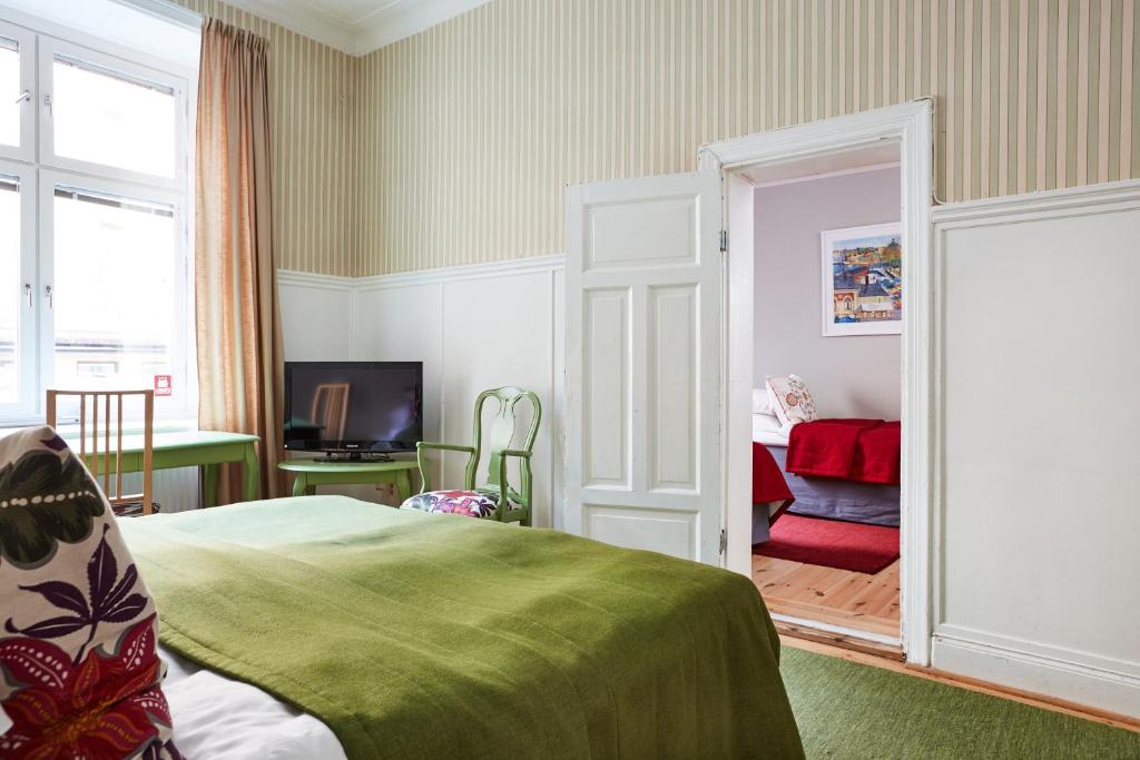 a bedroom with a bed and a door leading to a room at Hotel Hornsgatan in Stockholm