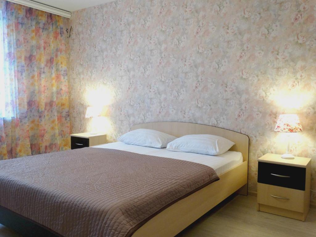 トゥーラにあるInndays on Pionerskaya 1-2のベッドルーム1室(ベッド1台、ナイトスタンド2台、ランプ2つ付)