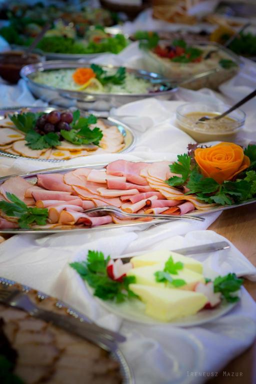 Platter of thinly sliced deli ham with parsley and carved vegetable garnish on buffet