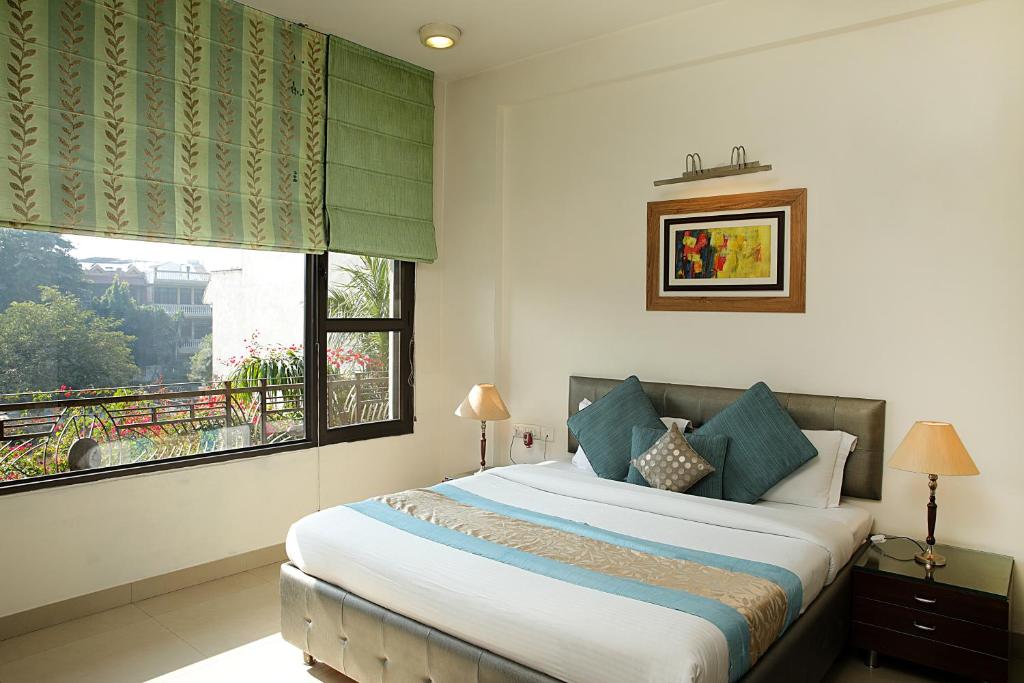 Un dormitorio con una cama grande y una ventana en Ahuja Residency Parklane, Gurgaon en Gurgaon