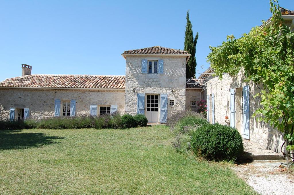 TouffaillesにあるMaison d'hôte Lapiadeの草の庭のある古い石造りの家