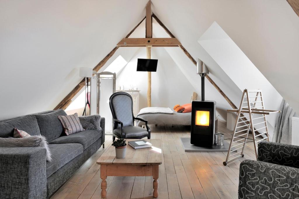 ein Wohnzimmer mit einem Sofa und einem Stuhl in der Unterkunft Un Loft a La Campagne in Saint-Jean-dʼArvey