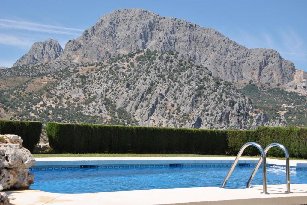 a swimming pool with a mountain in the background at Cortijo Las Monjas in Periana