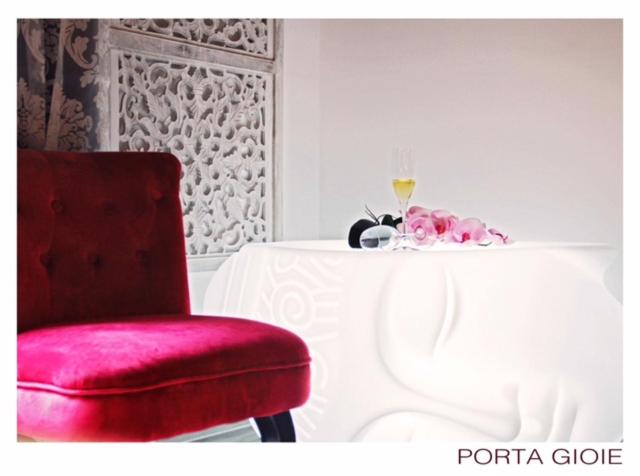 パレルモにあるCasa Busariの赤い椅子、ワインを飲みながらテーブルの横に座る
