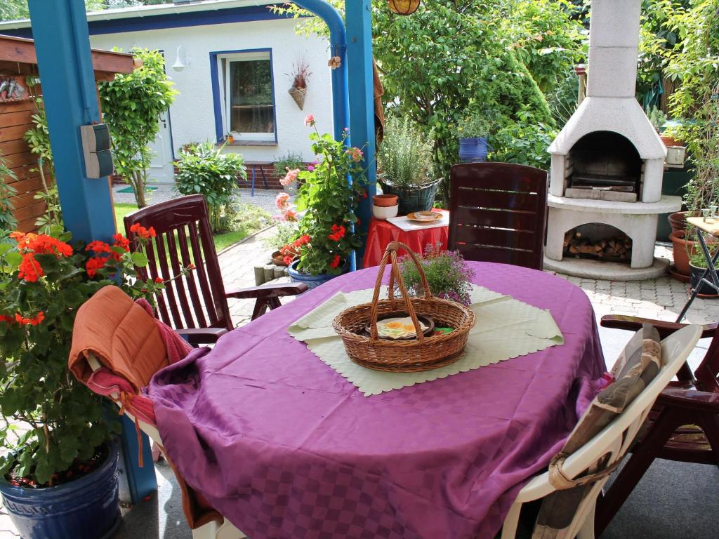 a table with a purple table cloth and a fireplace at Attractive Bungalow in Damshagen near the Sea in Damshagen