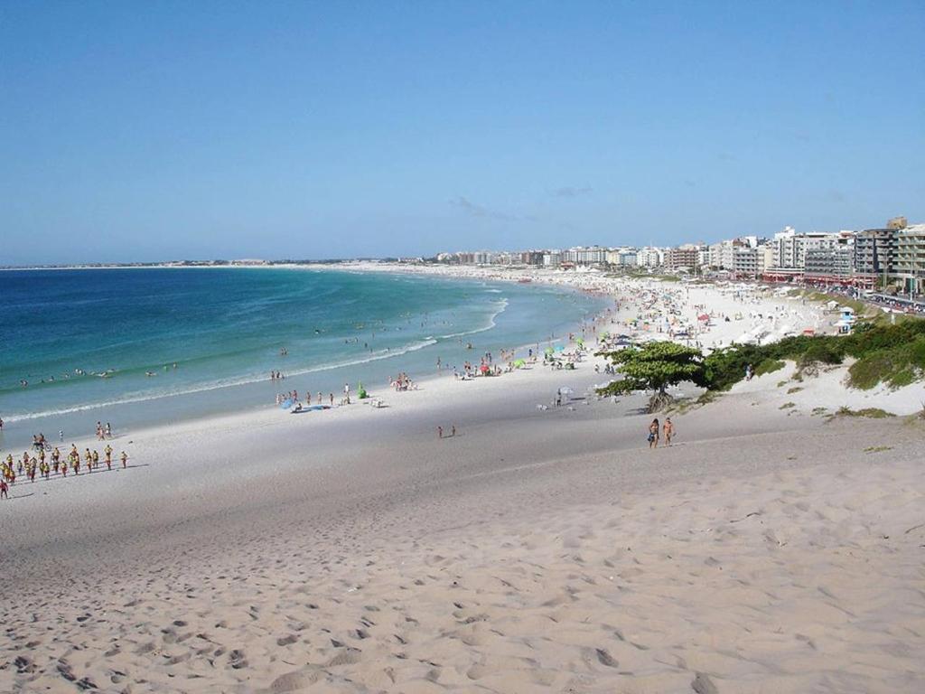 un grupo de personas en una playa cerca del océano en Casa Praia do Forte, en Cabo Frío