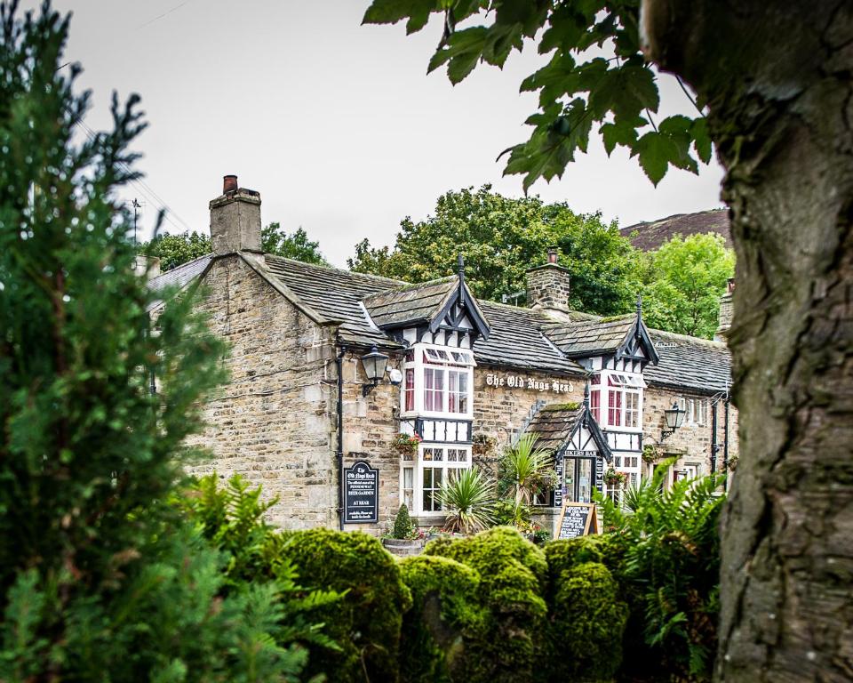 an old stone building with red and white windows at The Old Nag's Head in Edale