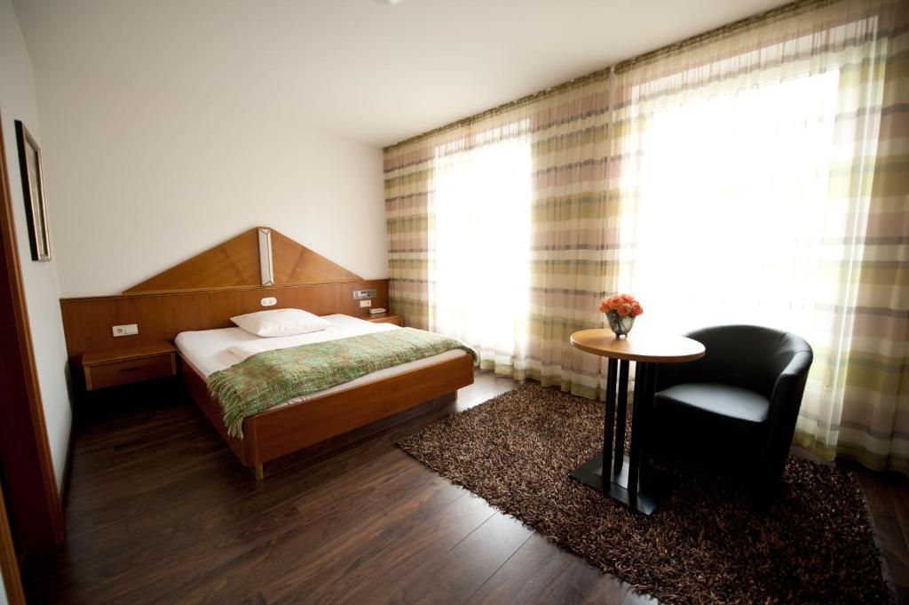 1 dormitorio con 1 cama, 1 mesa y 1 silla en Classic Hotel Kaarst, en Kaarst