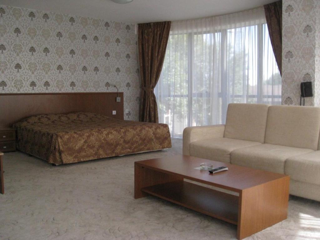 a living room with a bed and a couch at Hotel Elegance in Asenovgrad