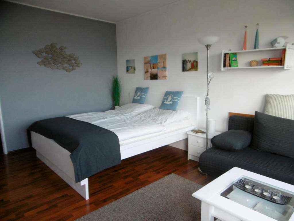 Burgtiefe auf Fehmarn にあるFerienwohnung am Südstrandの小さなベッドルーム(ベッド1台、ソファ付)