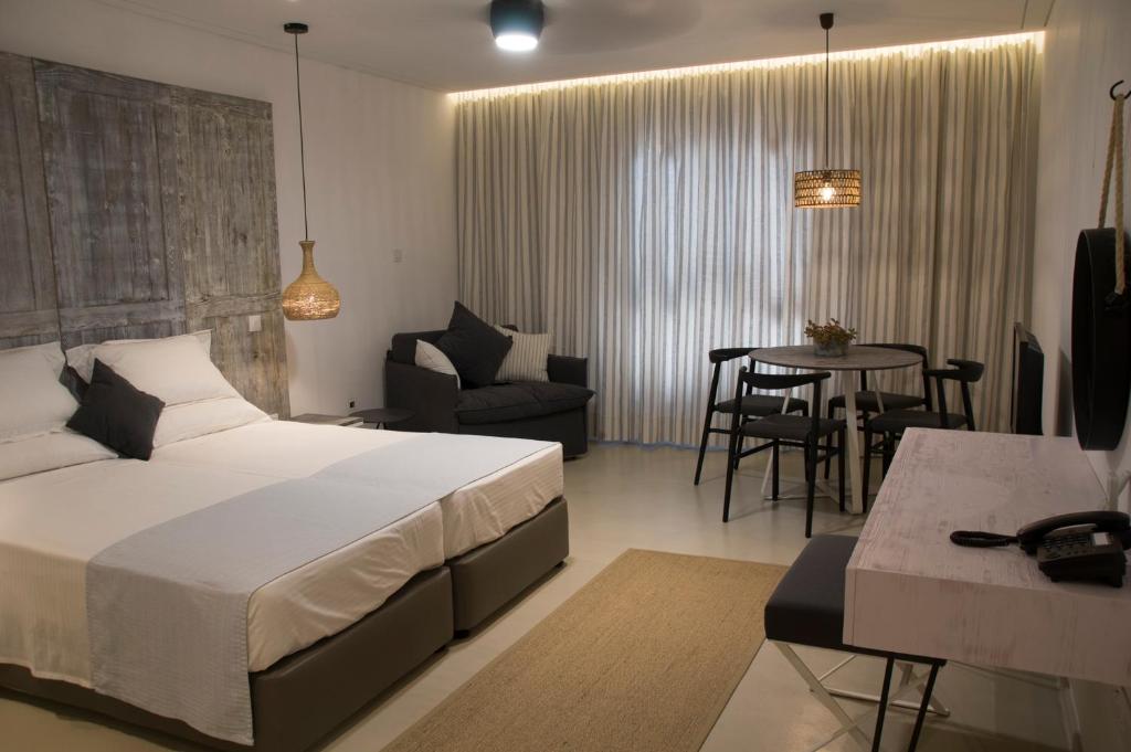 a bedroom with a bed and a table and chairs at Hylatio Tourist Village in Pissouri