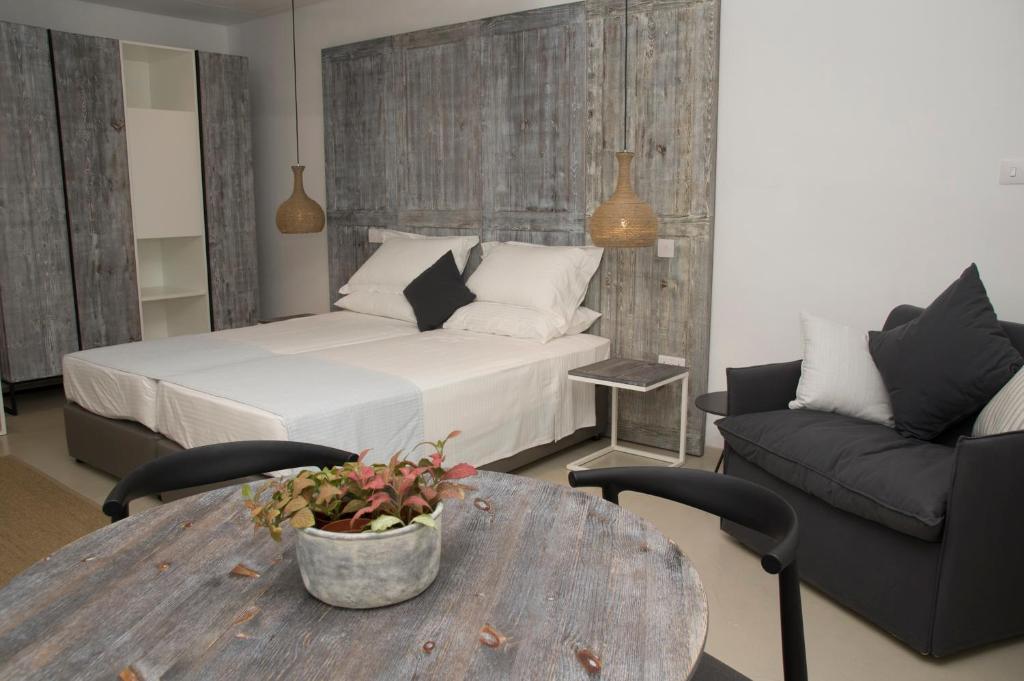a bedroom with a bed and a table and a couch at Hylatio Tourist Village in Pissouri