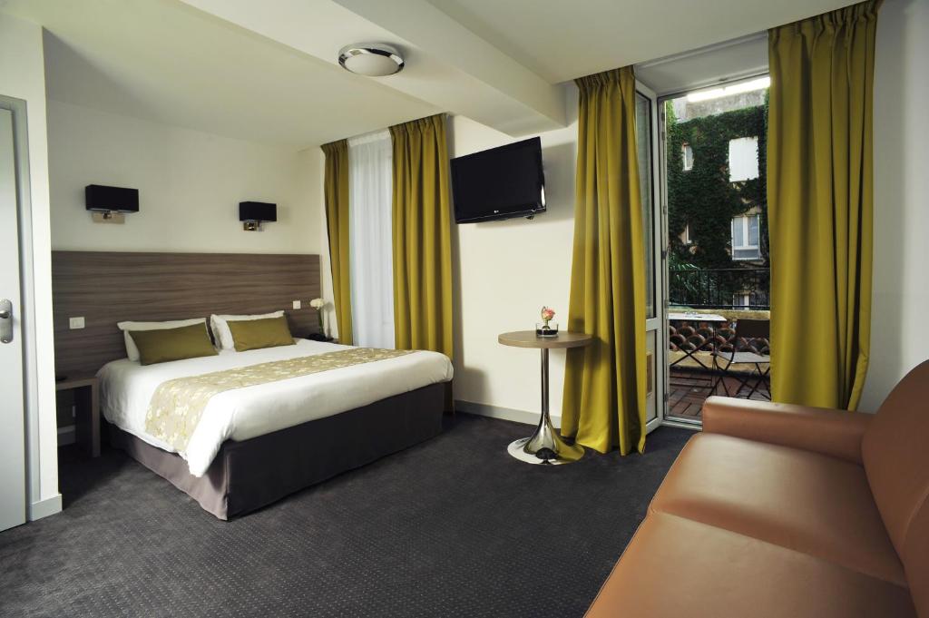 une chambre d'hôtel avec un lit et un canapé dans l'établissement Hôtel Atlantic, à La Rochelle