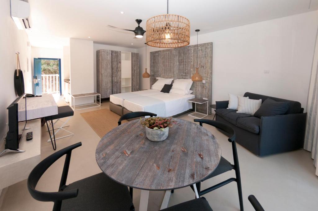 a living room with a bed and a table and chairs at Hylatio Tourist Village in Pissouri