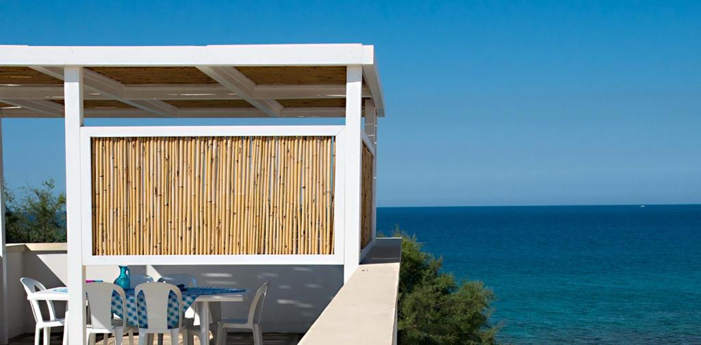 una terrazza con sedie e l'oceano sullo sfondo di Casa Celeste a Marina di Mancaversa